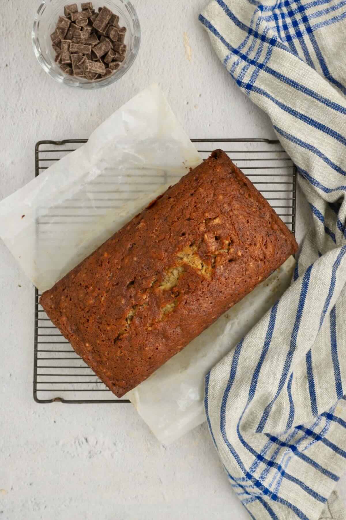 Just baked chocolate chunk banana bread, cooling on a wire rack.
