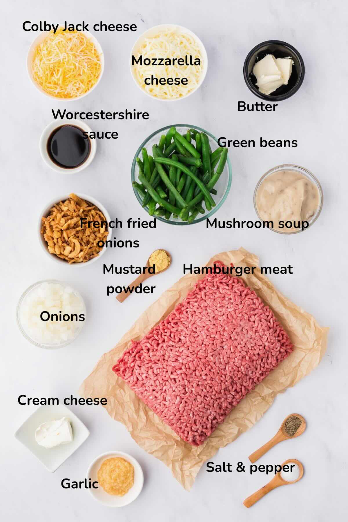 Ingredients for hamburger green bean casserole include hamburger meat, green beans, two kinds of cheese, and cream of mushroom soup.