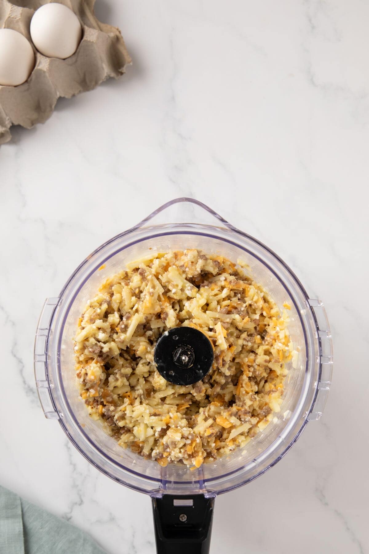 Hash browns, sausage, cheeses, and egg in a food processor.