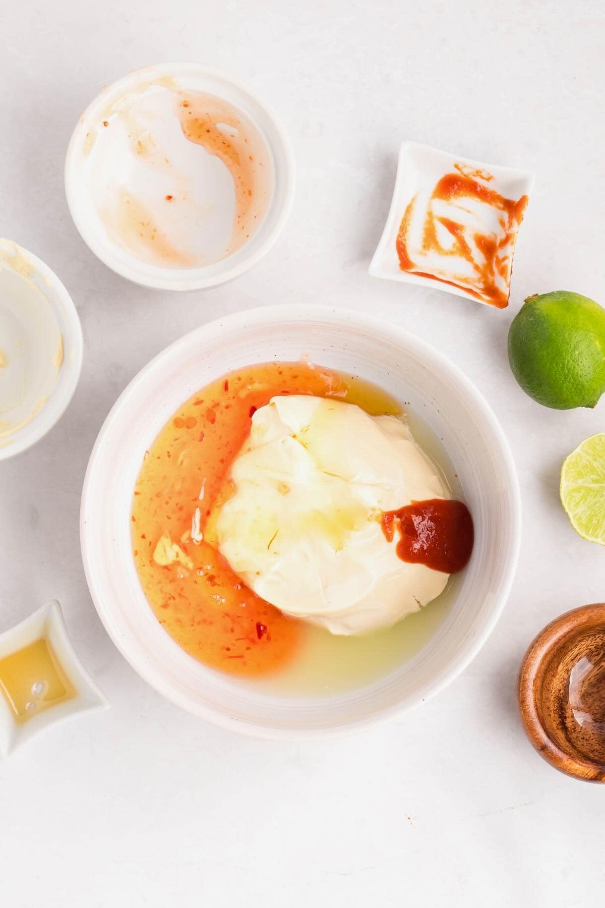A bowl full of mayo, sriracha, and other ingredients to make a sauce.