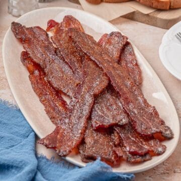 A serving plate with cooked brown sugar sweet and spicy bacon slices.