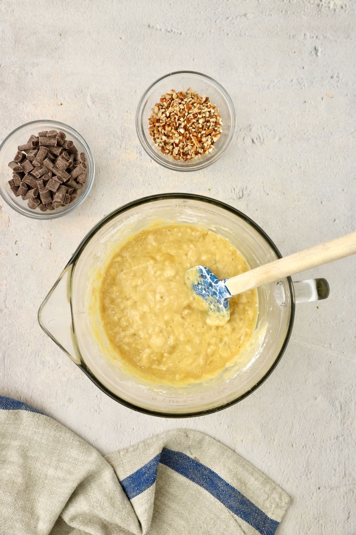Banana bread batter mixed in a glass bowl.
