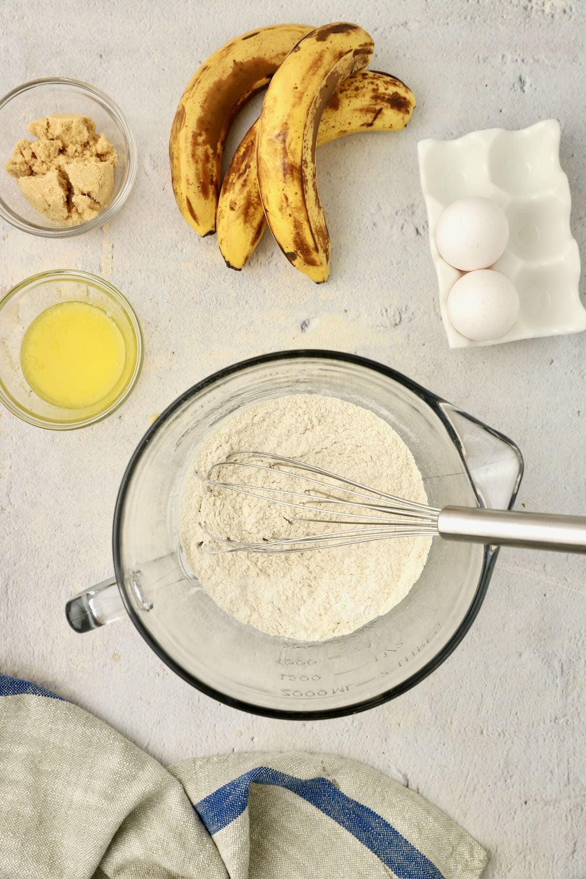 Flour, baking powder and soda in a mixing bowl with a whisk.