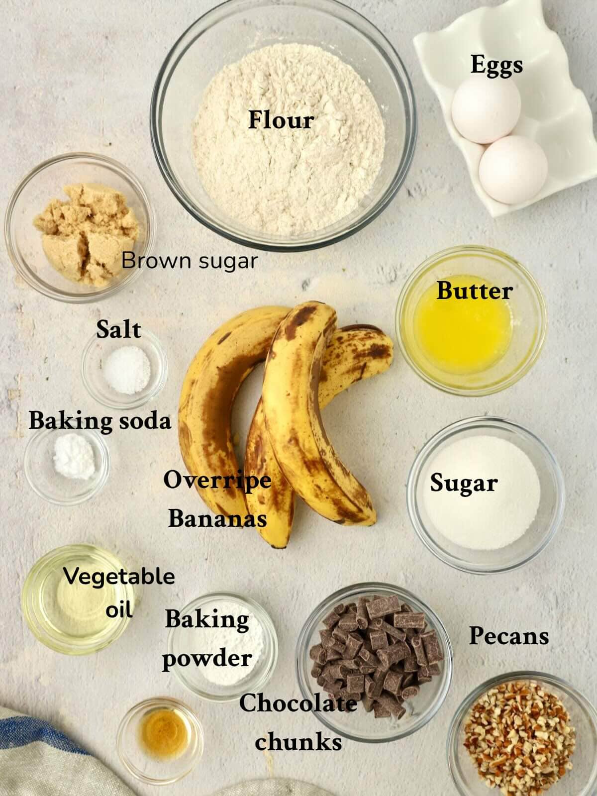 Ingredients for Chocolate Chunk Banana Muffins includes bananas, flour, butter, oil, pecans, and chocolate chunks.