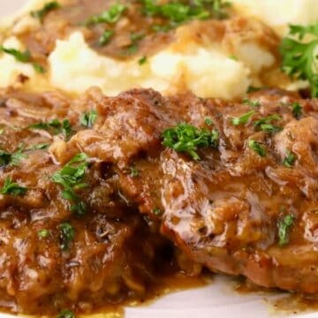 Smothered Southern country-style steak with onion gravy served over mashed potatoes