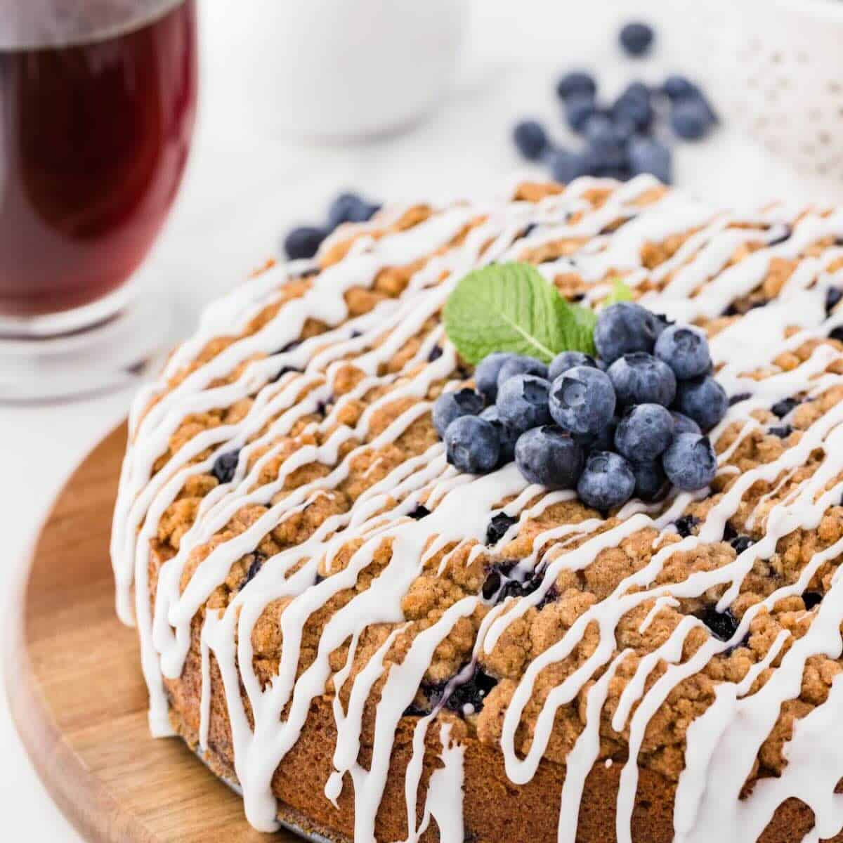 Lemon Blueberry Coffee Cake topped with streusel and glaze, and garnished with blueberries.