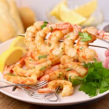 Oven-roasted shrimp on skewers that have been coated in garlic butter.