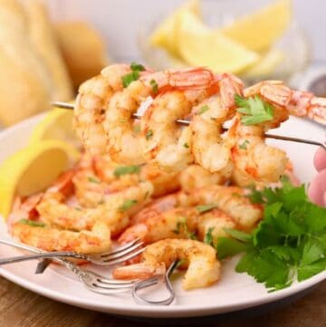 Oven-roasted shrimp on skewers that have been coated in garlic butter.