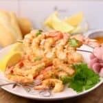 Oven-roasted shrimp on skewers that have been coated in garlic butter.