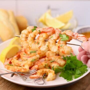 Oven-roasted shrimp on skewers that have been coated in garlic butter.