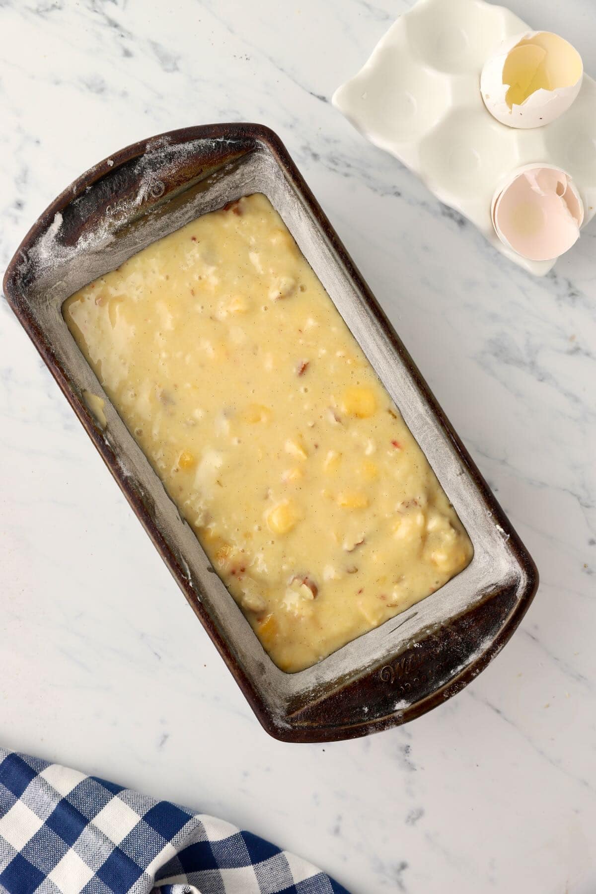 Peach bread batter in a loaf baking pan.