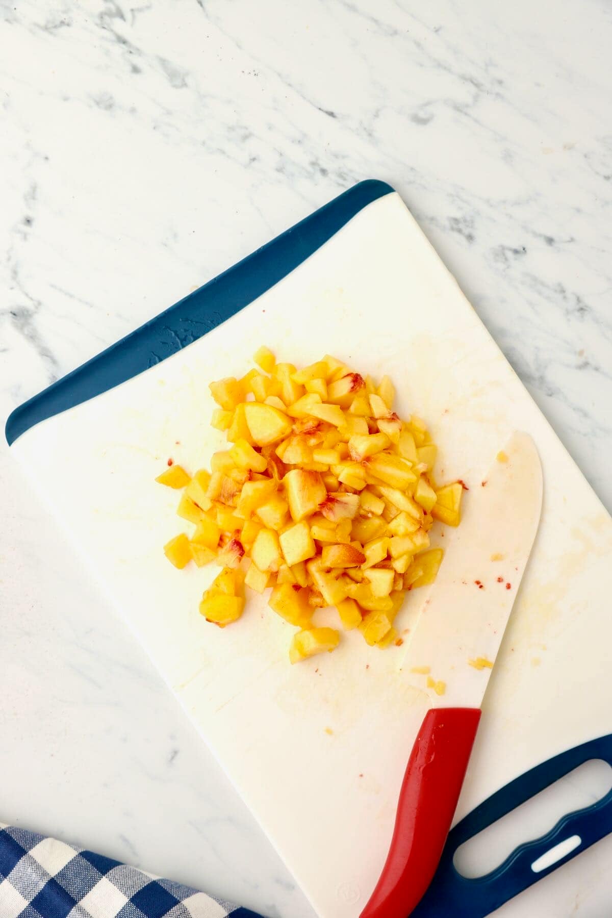 Chopping fresh peaches on a cutting board.