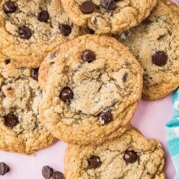 Chocolate chip cookies stacked on a counter.