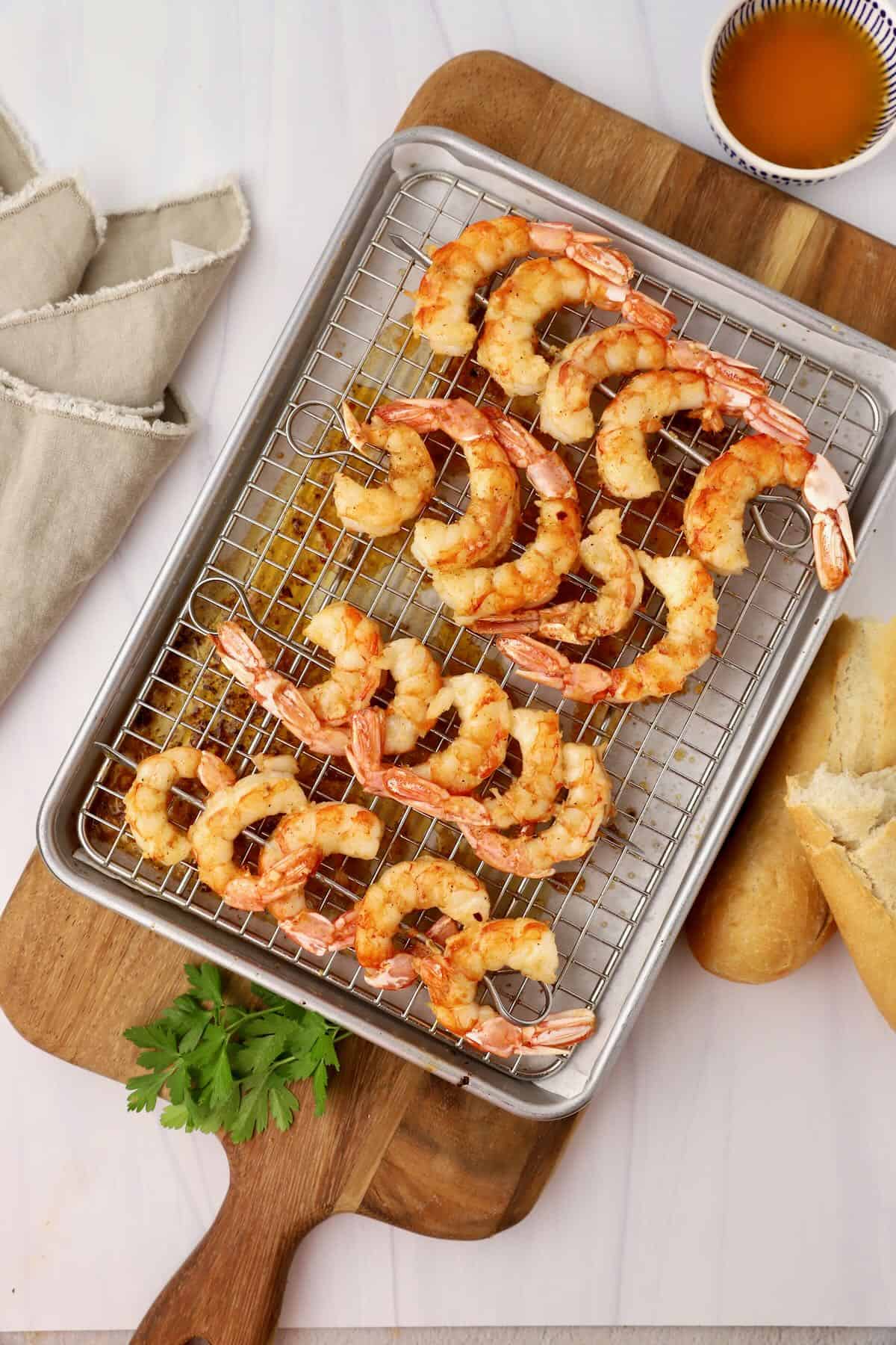 Oven roasted shrimp on skewers on a metal baking rack.