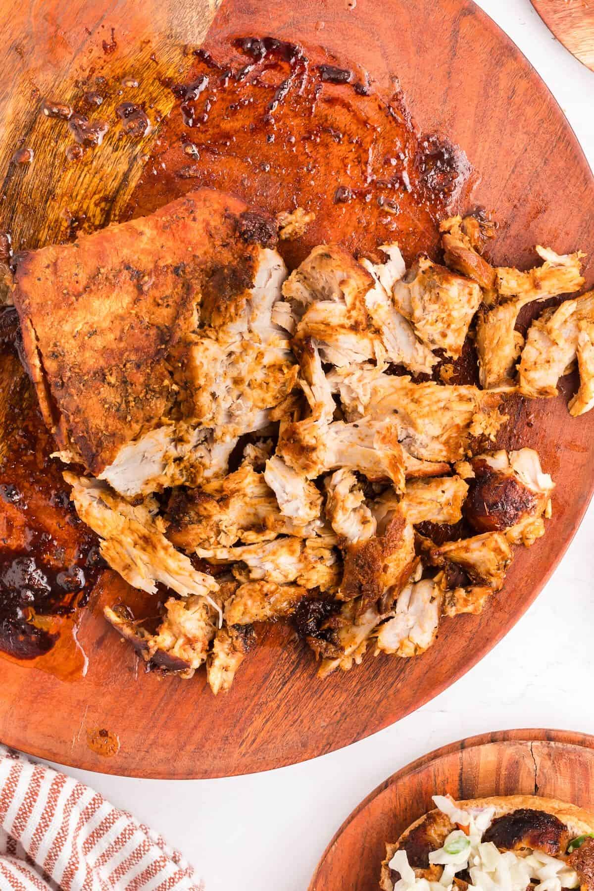 A pork butt cooked in an air fryer and the meat is being shredded.