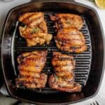 Juicy grilled boneless chicken thighs cooked on a cast-iron grill pan with dark grill marks