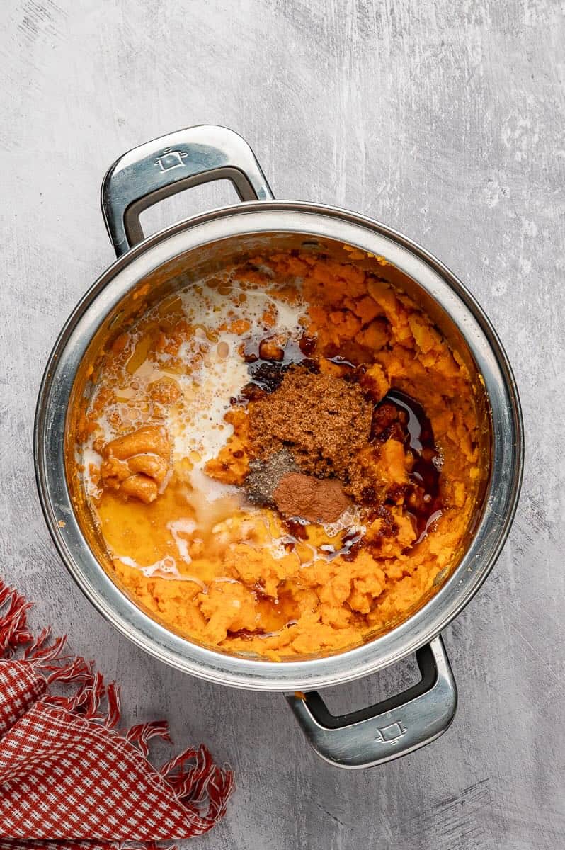 Mashed sweet potatoes, cream, brown butter and seasonings in a saucepan.