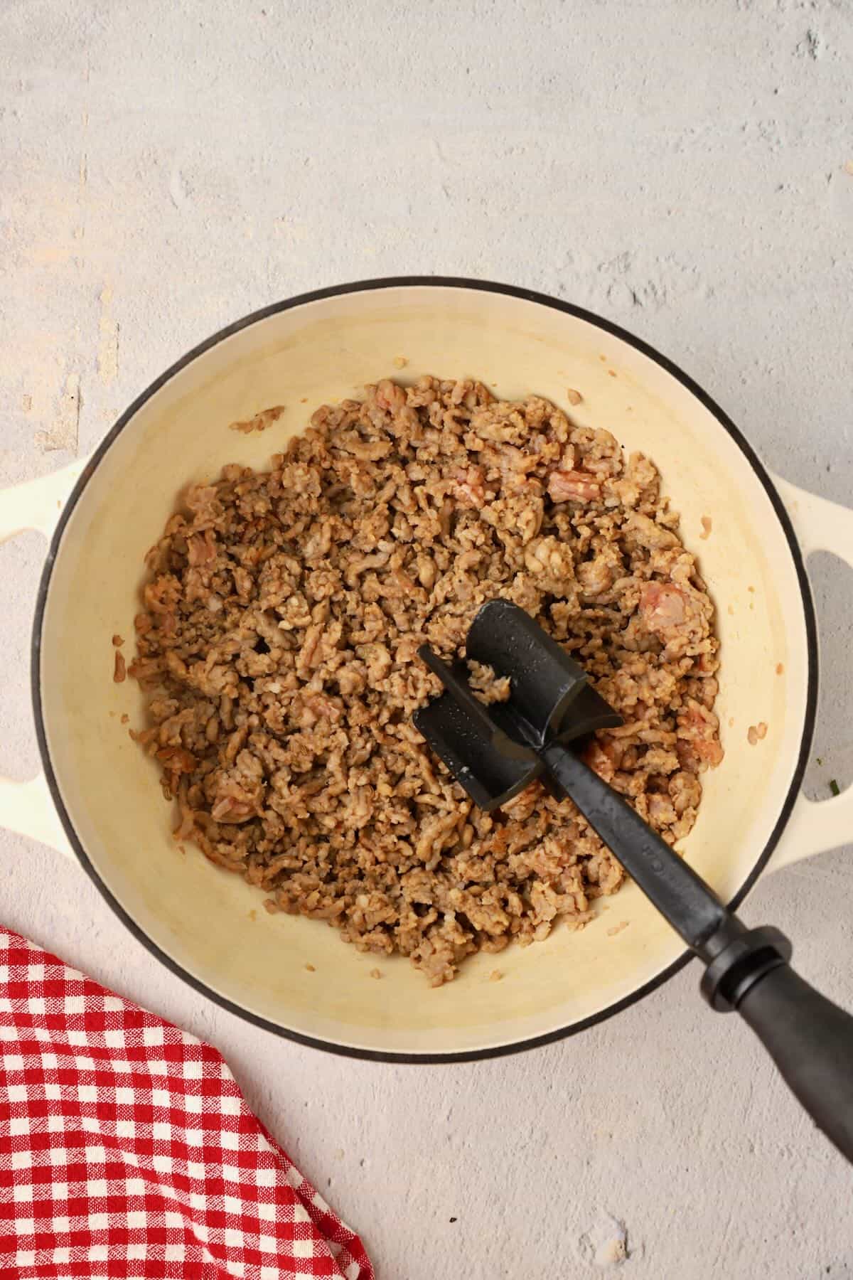 Browning sausage in a large pot.