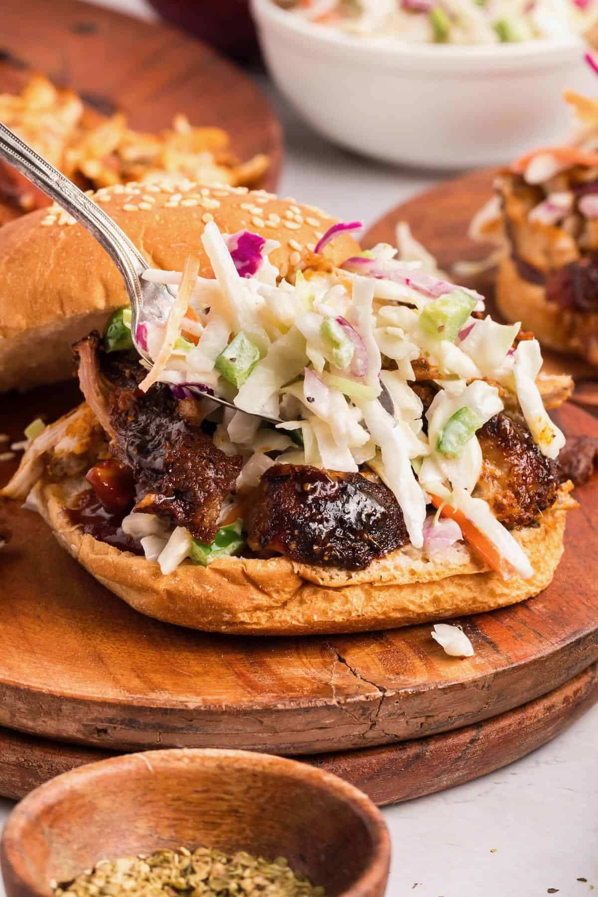 Spicy slaw topping pulled pork on a toasted bun.