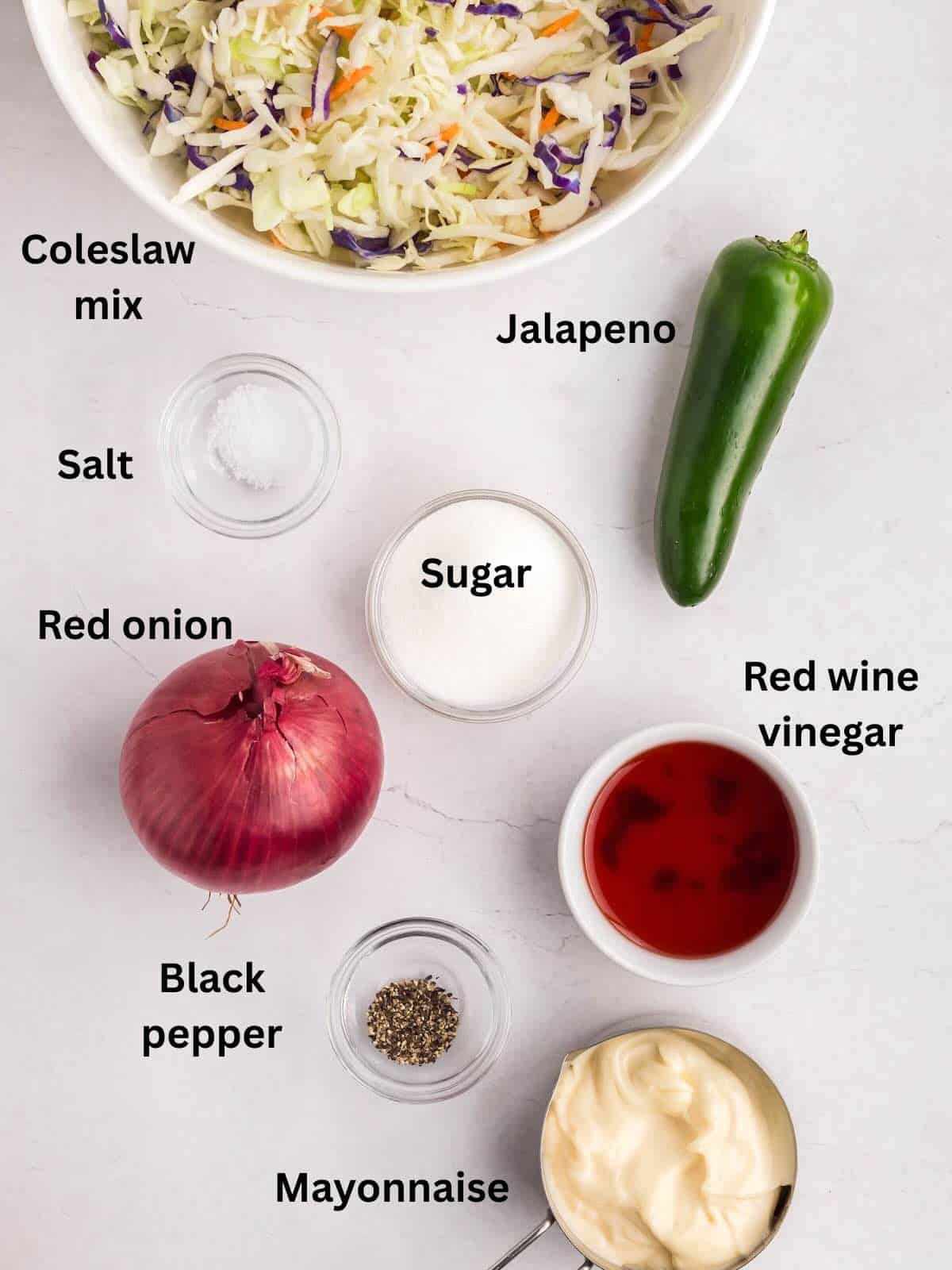 Ingredients to make spicy coleslaw include bagged coleslaw, jalapenos, onions, and dressing ingredients.
