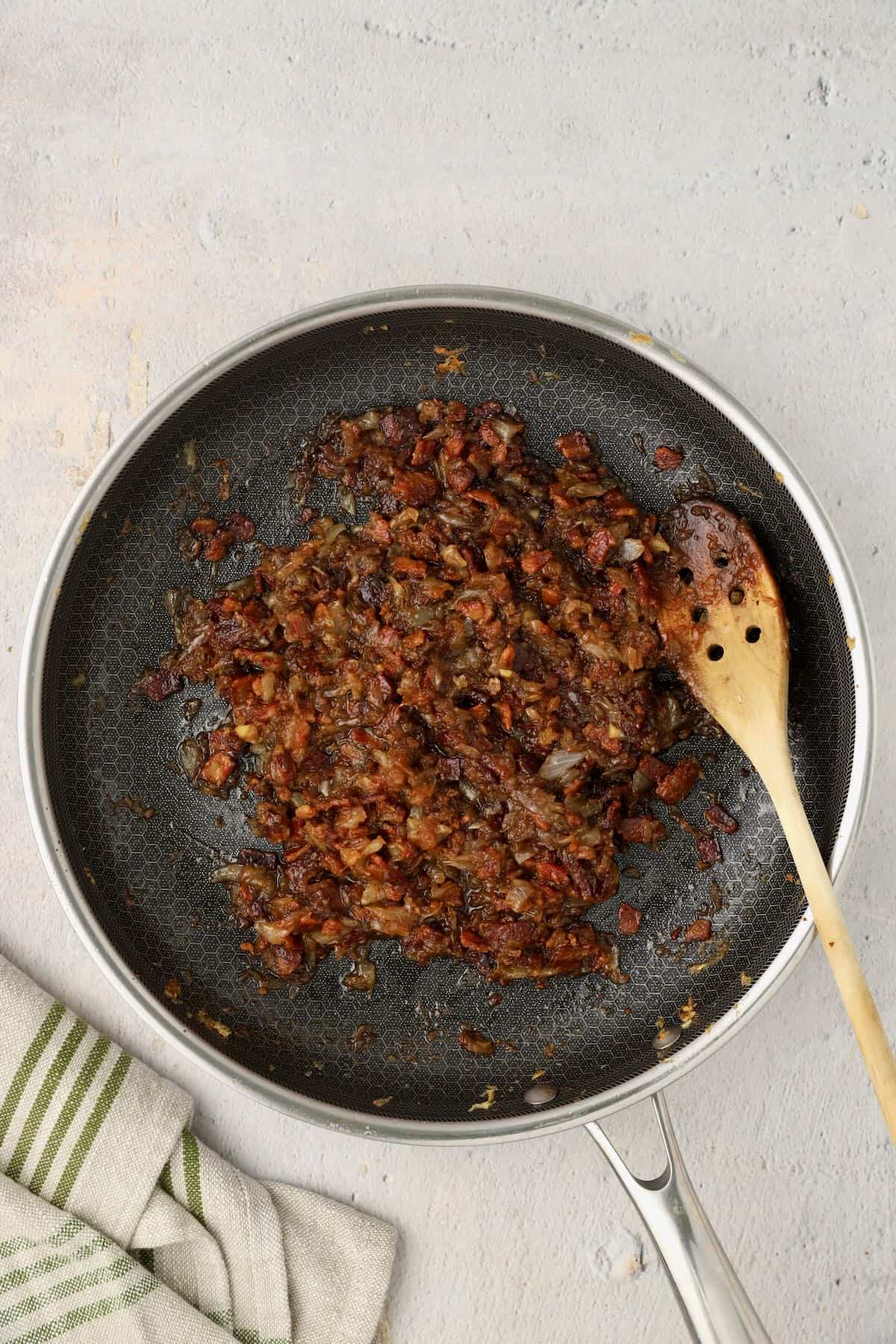Caramelized onions, bacon, and other ingredients added to a skillet to make this savory jam.