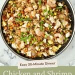 A large skillet full of chicken and shrimp fried rice with vegetables and eggs.