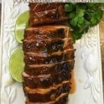 Pinterest pin with a sliced grilled pork tenderloin topped with apricot glaze on a serving dish.