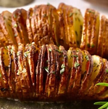 Crispy oven-baked Hasselback potatoes brushed with garlic herb butter and rosemary.