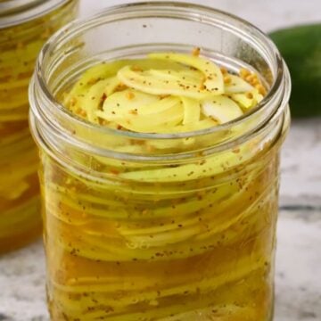 Jar of sweet pickled green tomatoes and Vidalia onions in refrigerator pickle brine.