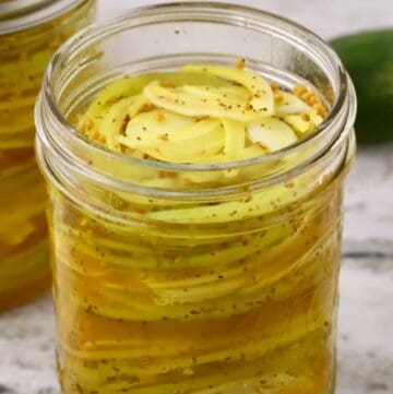 Jar of sweet pickled green tomatoes and Vidalia onions in refrigerator pickle brine.