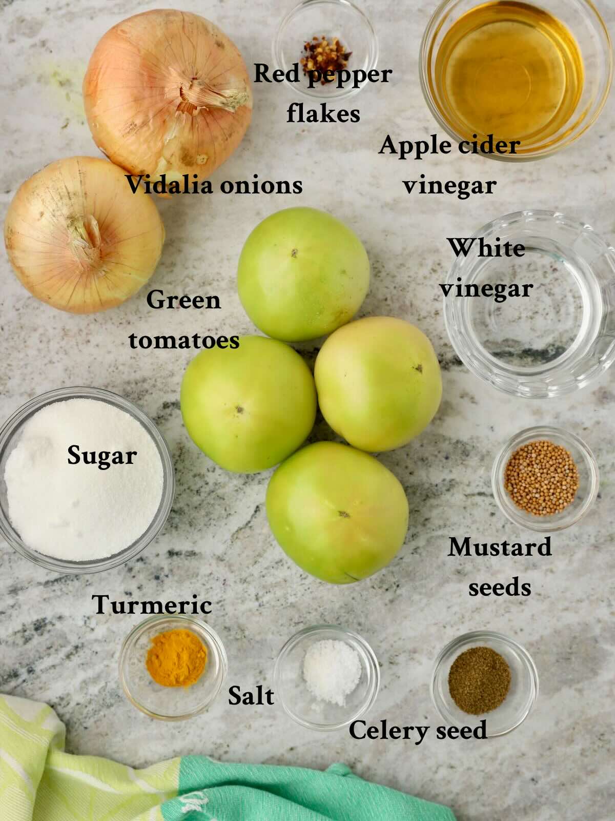 Ingredients for pickled green tomatoes and onions including vinegars and seasonings.