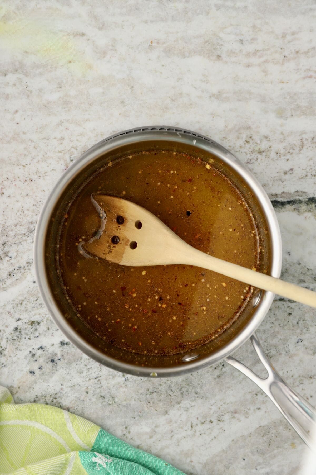 A saucepan with white and apple cider vinegar and pickling spices.