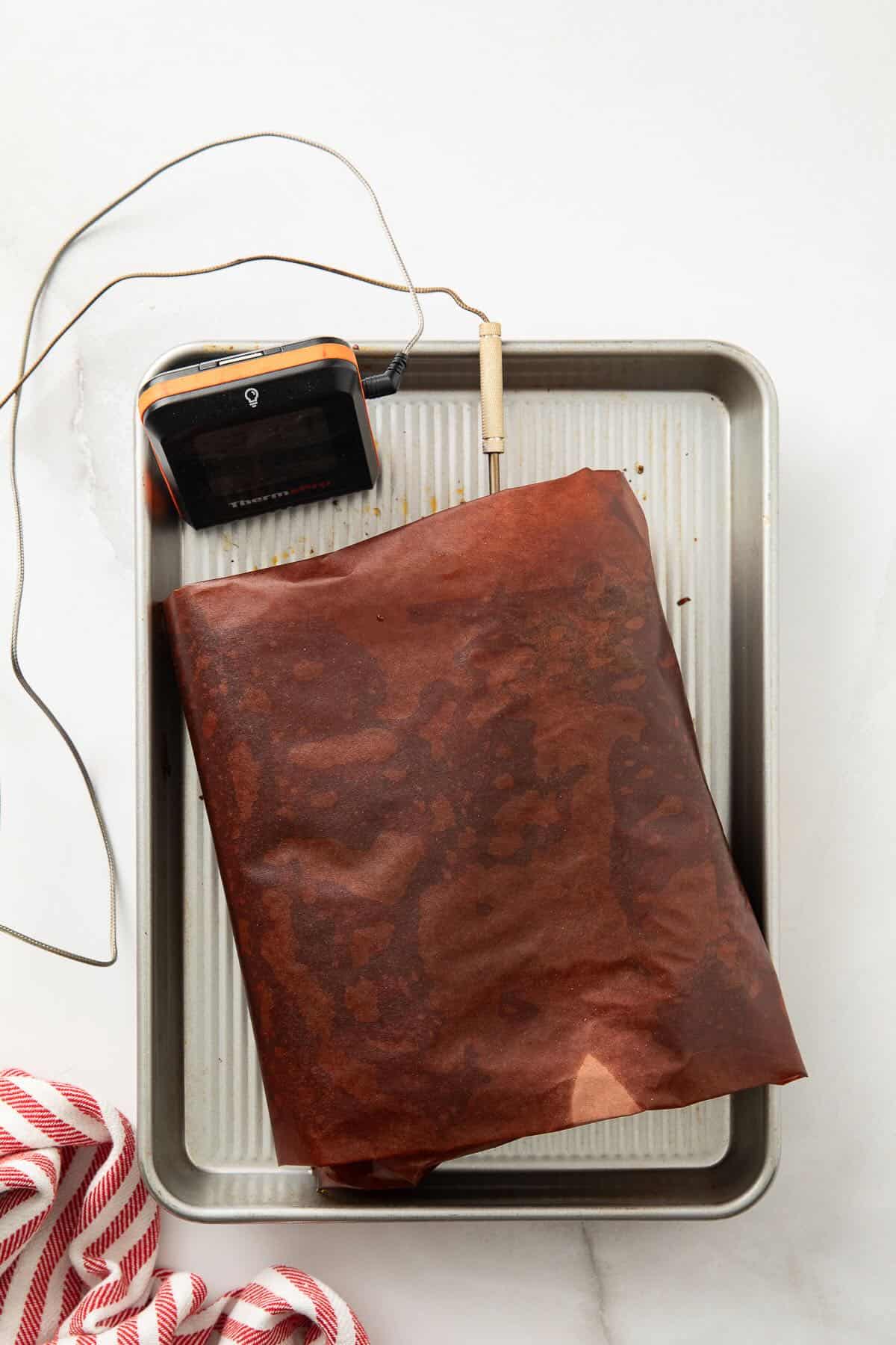 A smoked chuck roast wrapped in butcher paper resting after smoking.
