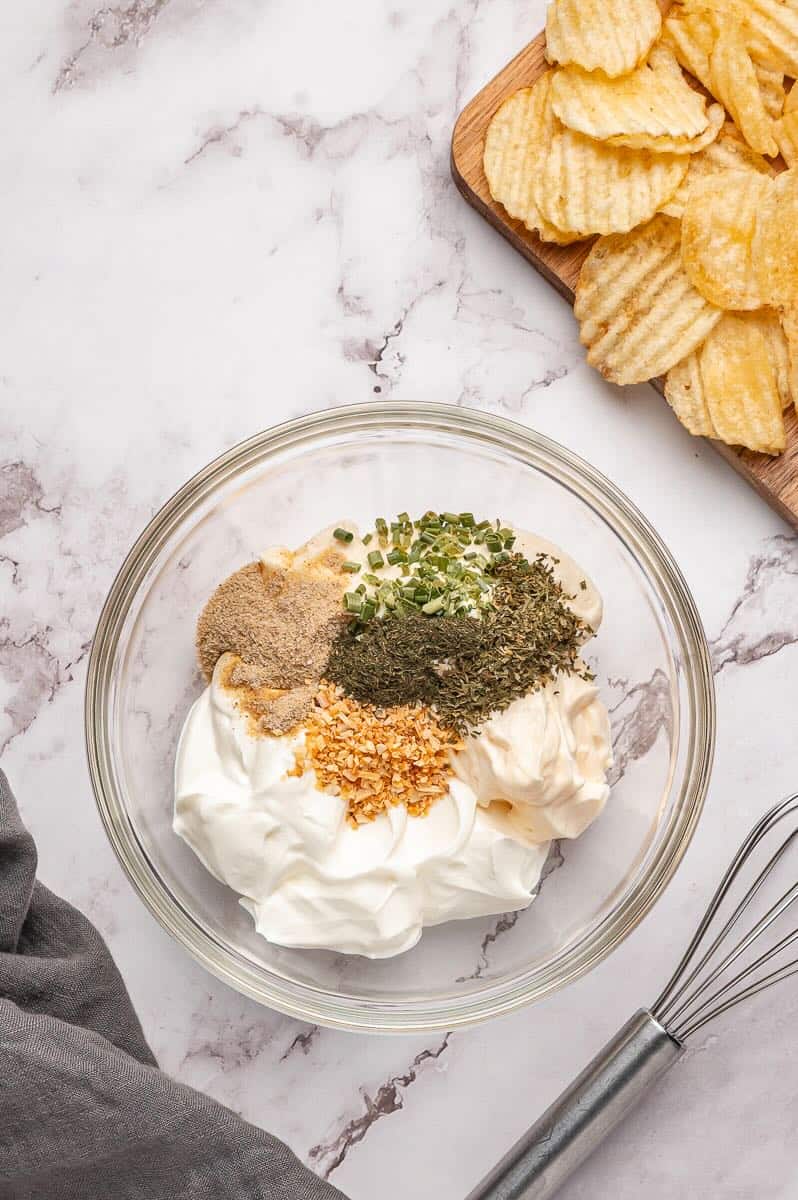 Ingredients to make Beau Monde Dip are added to a bowl.