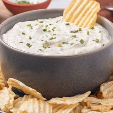 Beau Monde Dip in a bowl surrounded by ruffled potato chips.