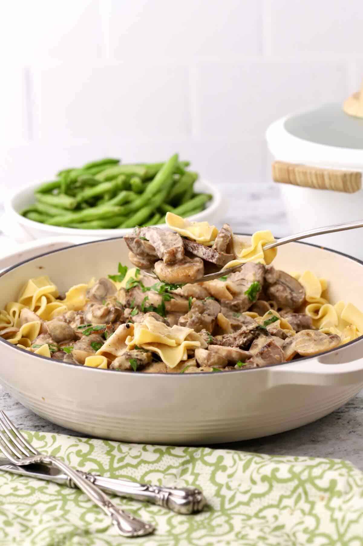 A Dutch oven full of beef stroganoff made with leftover steak and noodles.