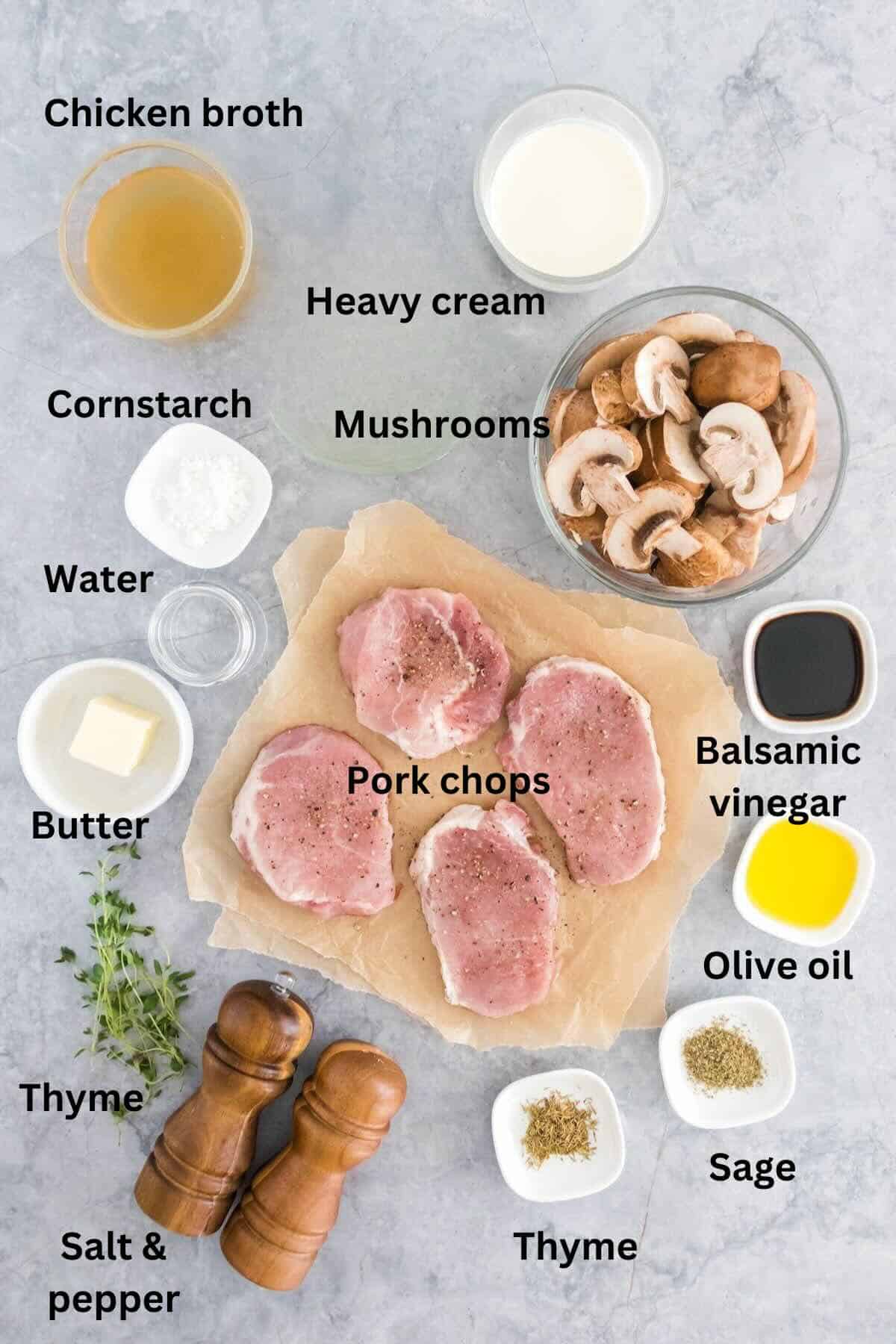Ingredients for mushroom pork chops on a counter include heavy cream, mushrooms, balsamic vinegar and pork chops.