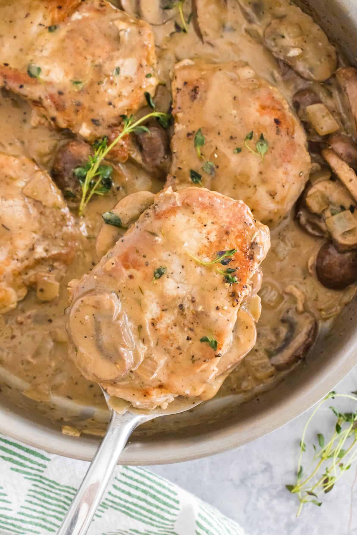 Serving a pork chops cooked in a mushroom pan sauce.