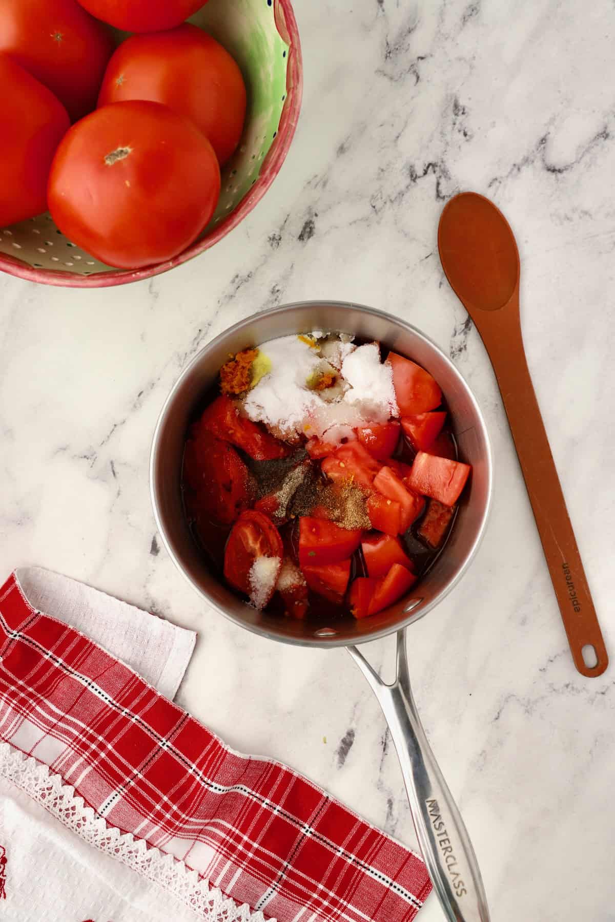 Chopped tomatoes, vinegar, sugar, and seasonings in a saucepan.
