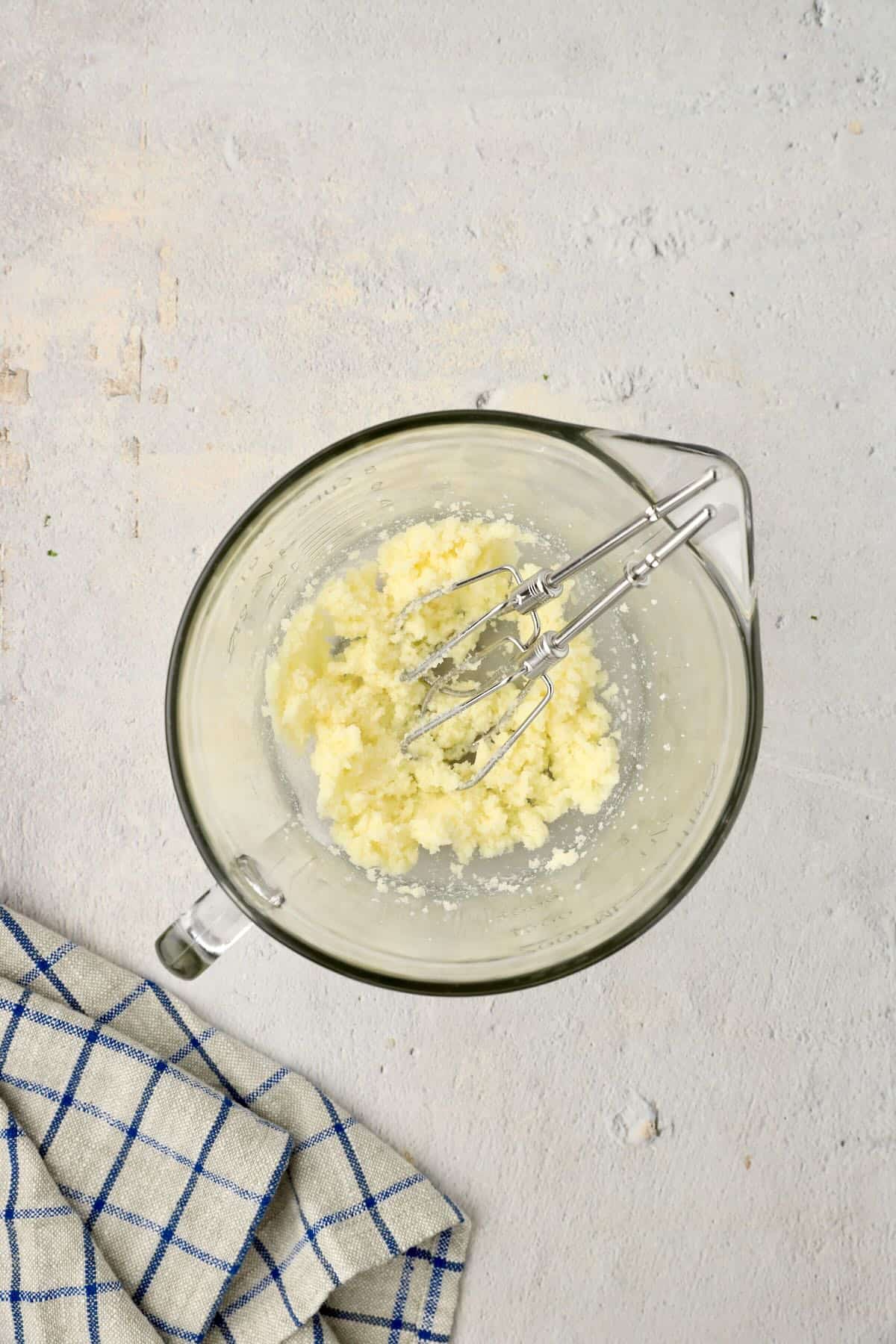 Using an electric mixer to cream butter and sugar.