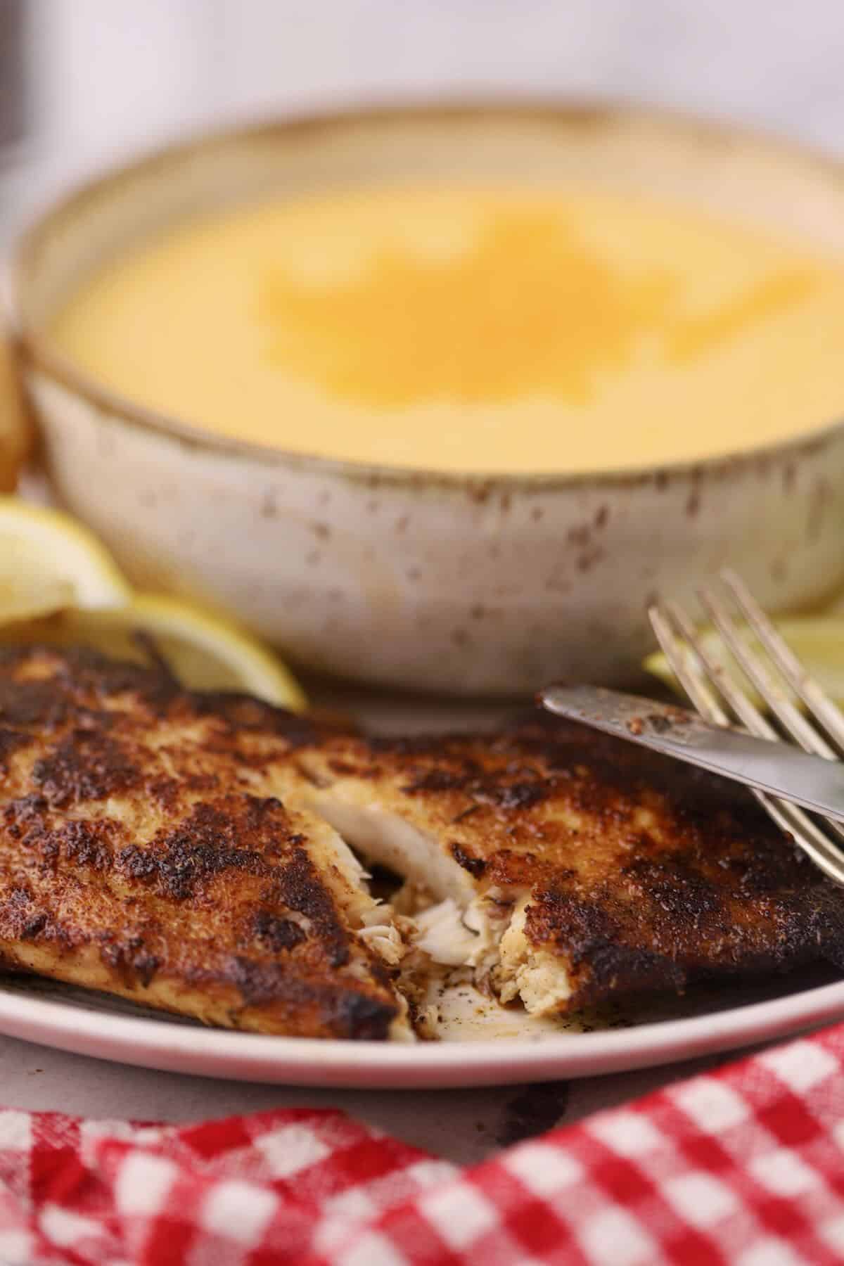 A blackened redfish fillet cut open to show the flakes.
