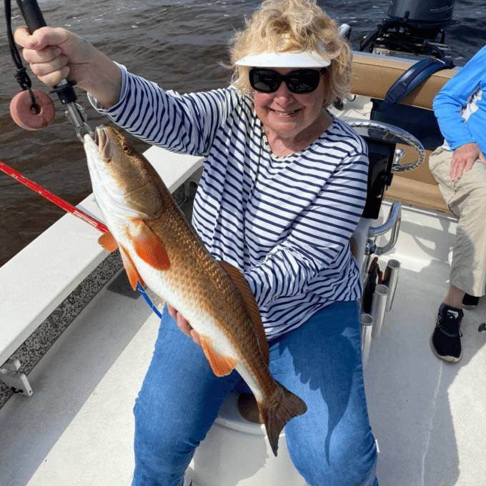 Sharon showing off a large redfish, she just caught in the Gulf.