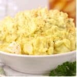 A white bowl full of creamy Southern Potato Salad.