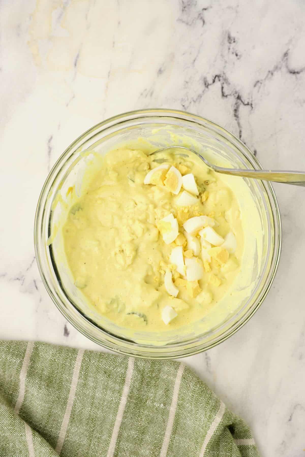 Add chopped eggs to the potatoes and dressing.