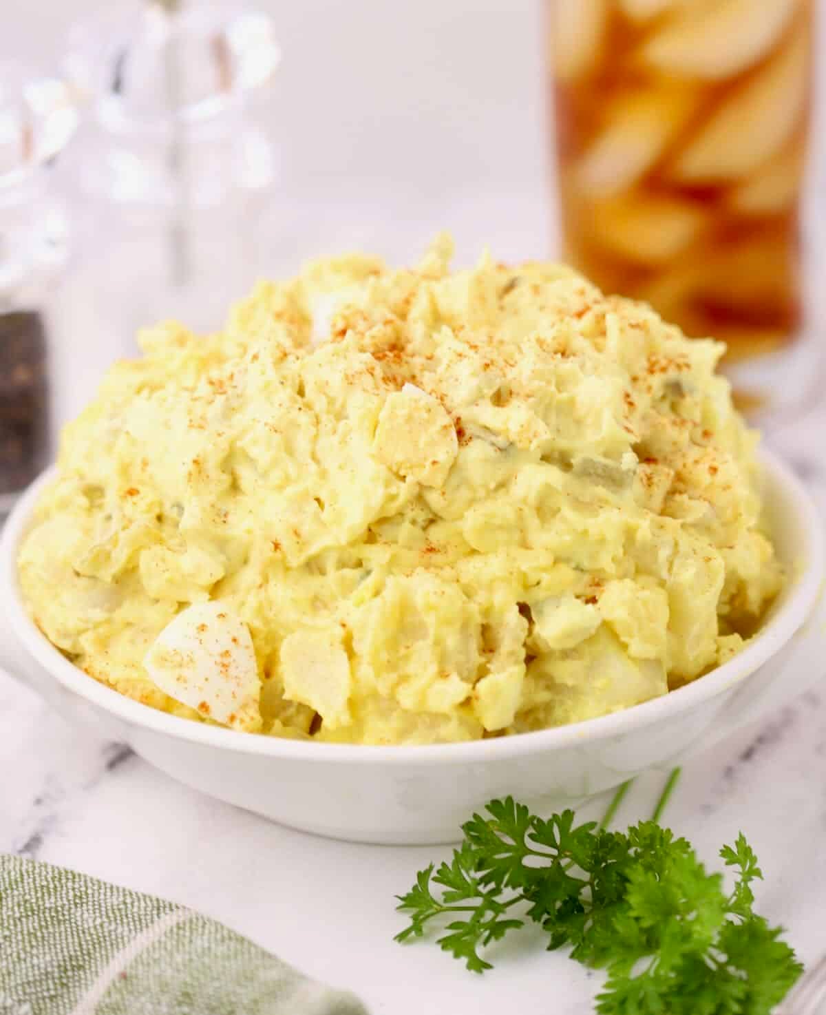 Creamy old-fashioned Southern potato salad piled high in a white bowl.