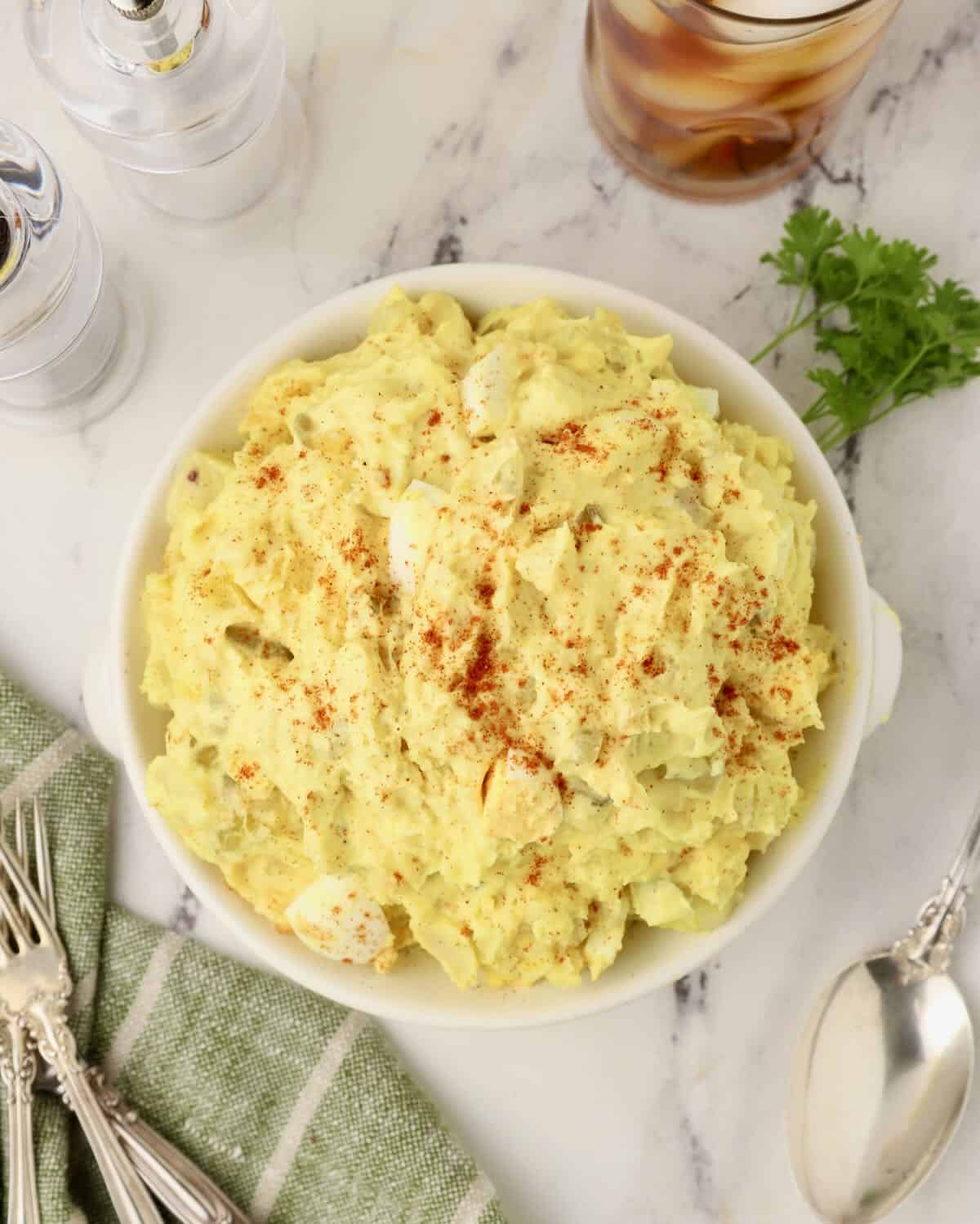 Southern potato salad in a bowl with a napkin, fork, and knife.
