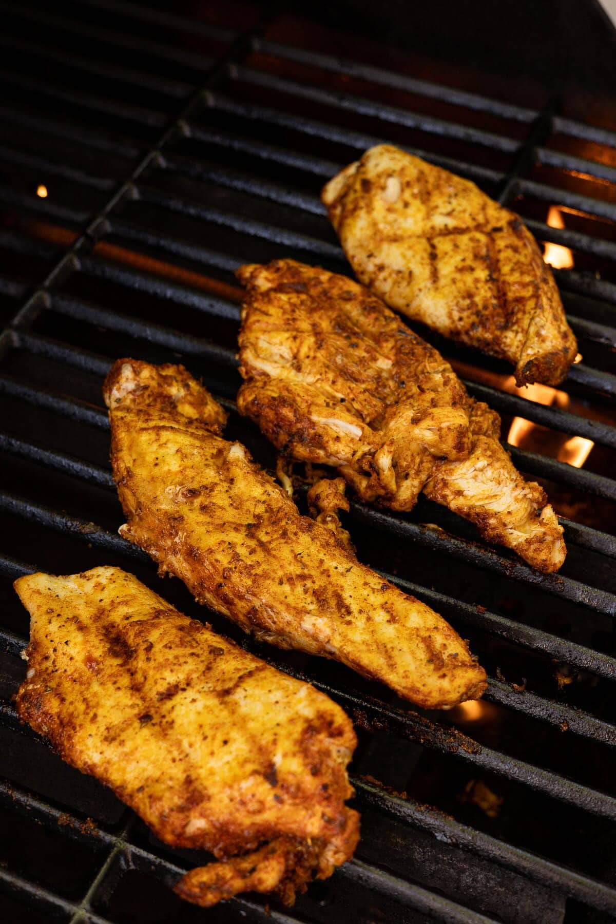 Four chicken breasts being grilled on a Big Green Egg.