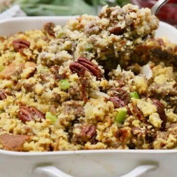 Baked cornbread dressing with sausage and pecans with a spoonful.