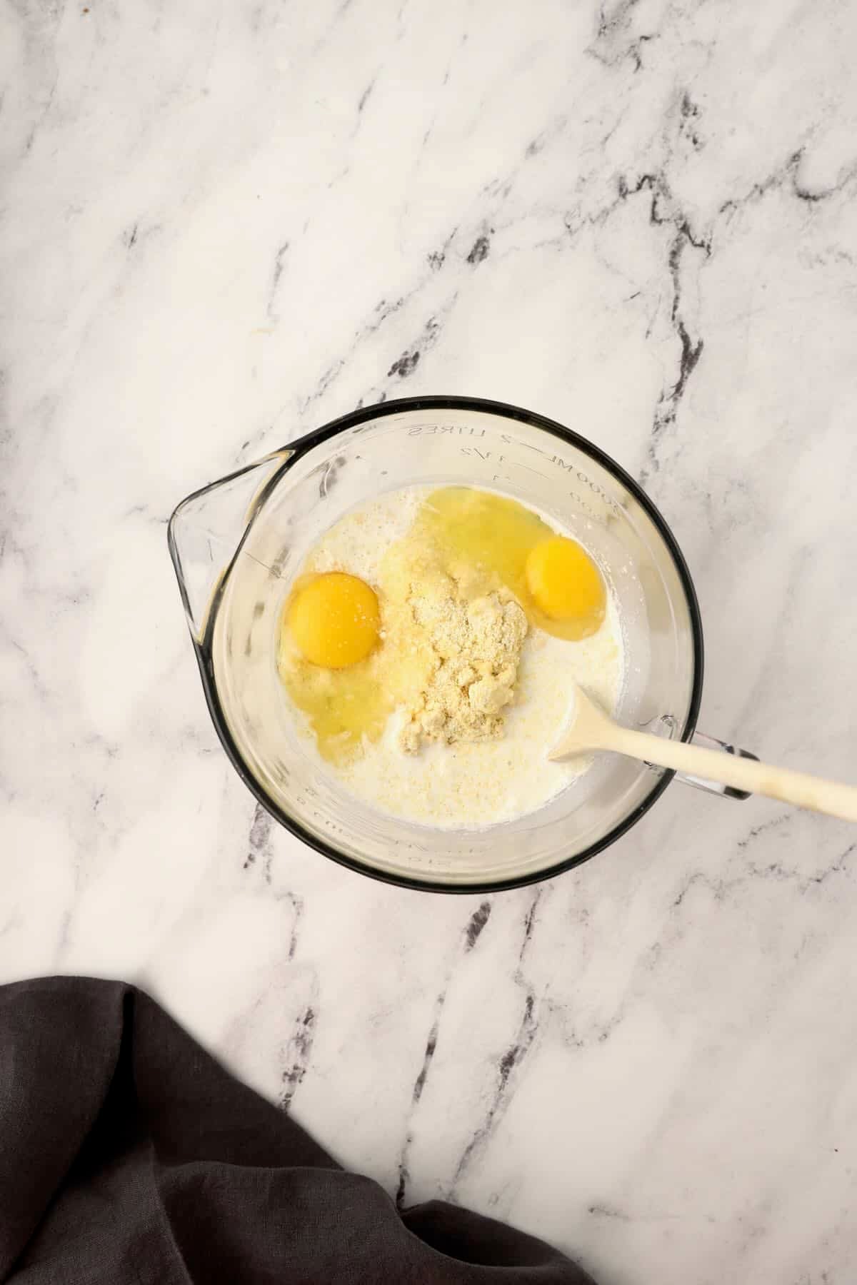 Jiffy cornbread batter is being mixed with eggs and milk.