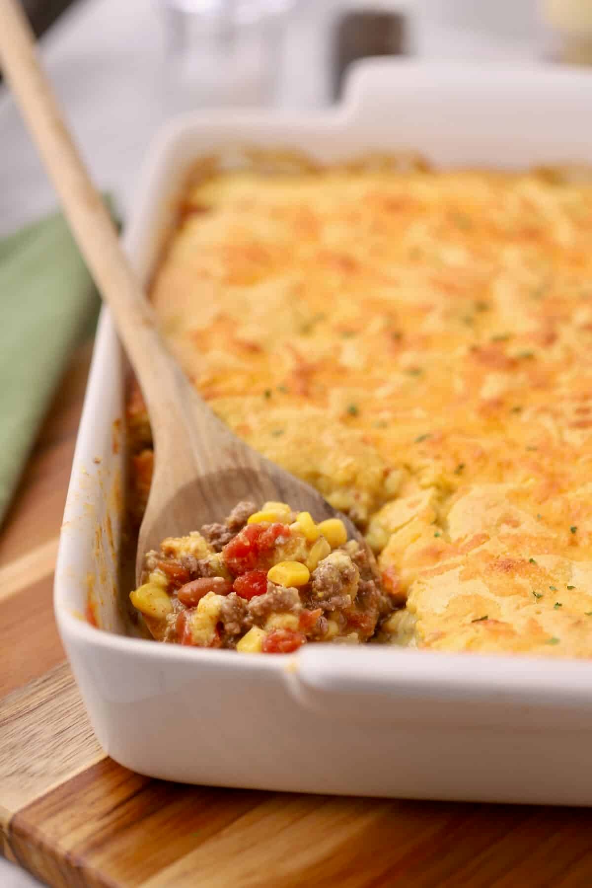 Baked Cowboy Cornbread Casserole with a golden cornbread topping in a white dish.